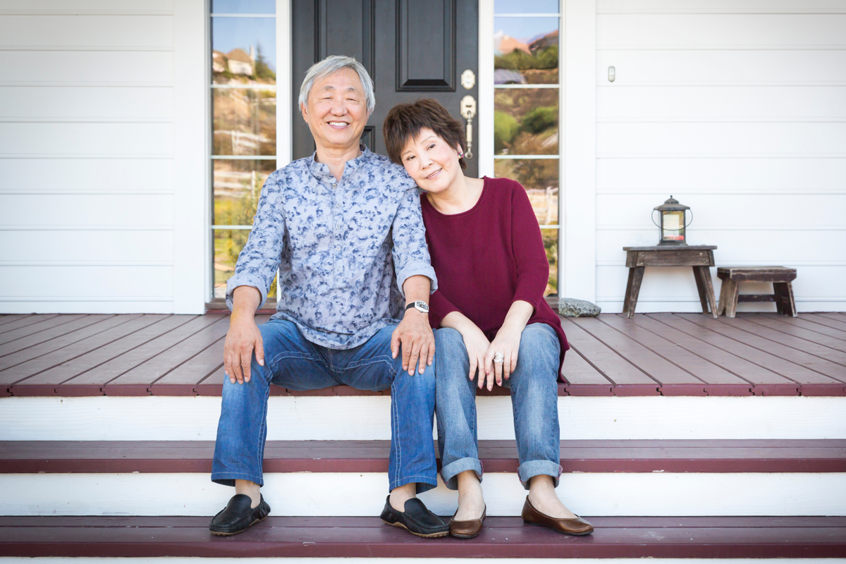 Senior couple smiling outside their home, representing aging in place with confidence