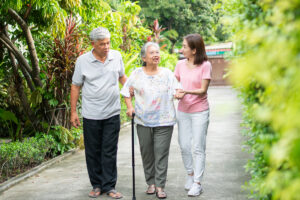Daughter holding hands with senior mother while touring an assisted living community together